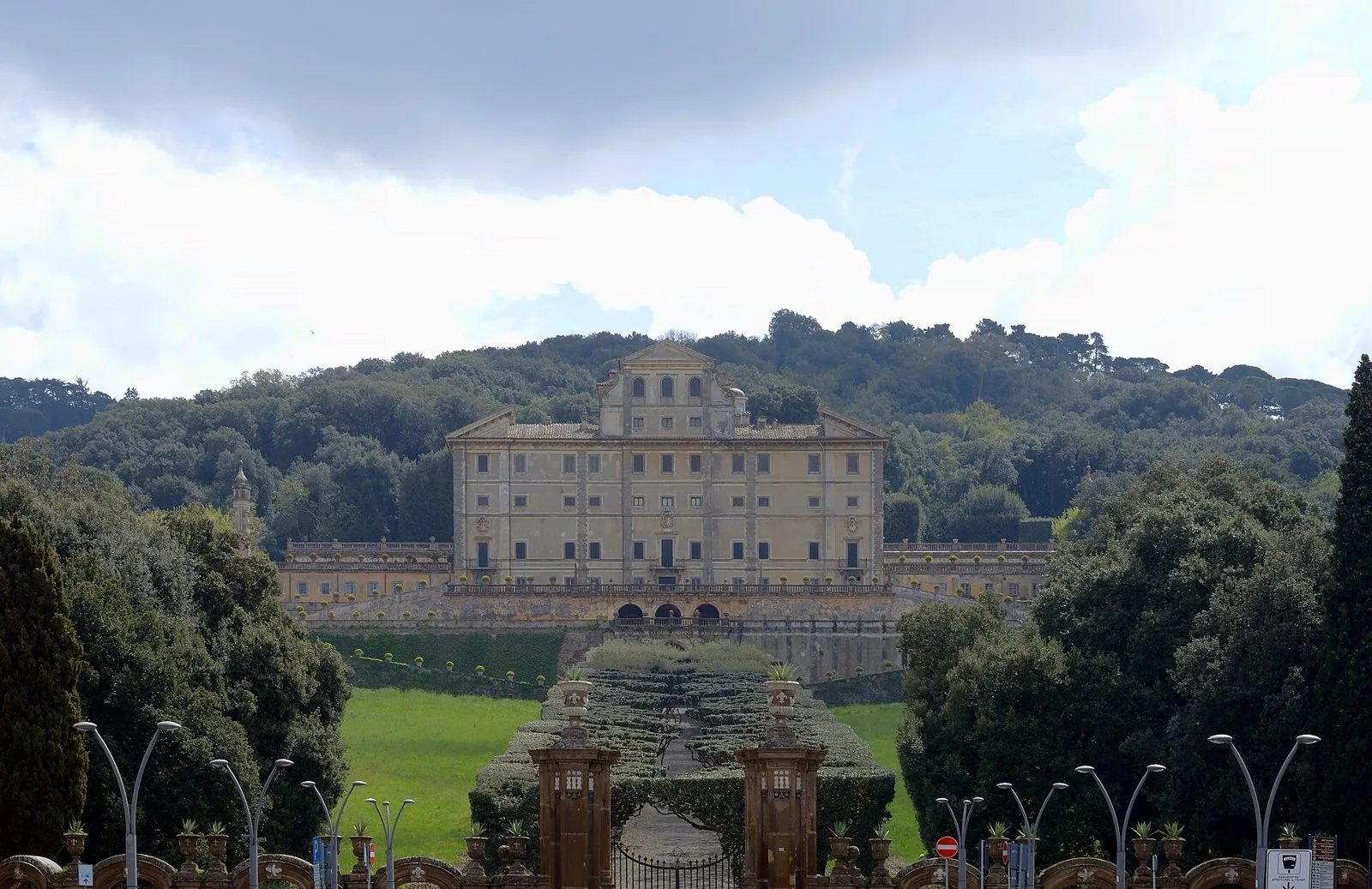 Villa Aldobrandini a Frascati vista dal viale d'ingresso, con il cancello, le siepi e il bosco alle spalle del palazzo